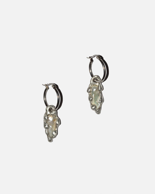 Pair of stainless steel hoop earrings with freshwater pearl charms on a white background